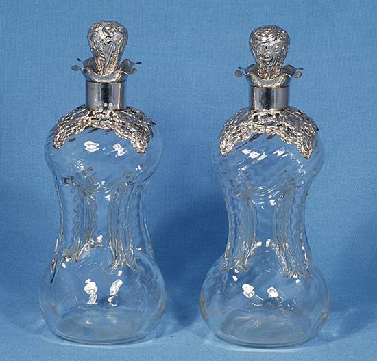 A pair of Edwardian silver mounted waisted glass decanter and stoppers,